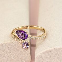 Elevate your elegance with a "toi et moi" ring featuring a teardrop-shaped amethyst and a round pink sapphire set on a band of white sapphires. Crafted from solid 10k yellow gold, this ring showcases an amethyst of 0.6 ct, a lab-created pink sapphire of 0.4 ct, and white sapphires. Luxury Pink Sapphire Jewelry For Promise, Fine Jewelry Teardrop Purple Ring, Elegant Teardrop Purple Amethyst Ring, Fine Jewelry Purple Teardrop Ring, Purple Teardrop Amethyst Ring For Anniversary, Purple Teardrop Fine Jewelry Ring, Teardrop Amethyst Ring For Anniversary, Elegant Purple Teardrop Amethyst Ring, Purple Amethyst Teardrop Ring