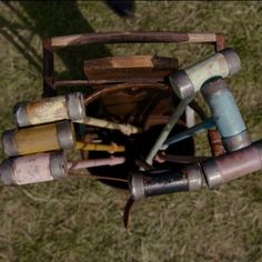 an overhead view of many different colored objects in a basket on the ground with grass