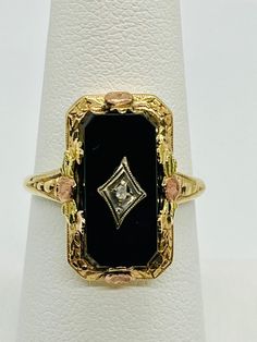 Vintage 10K yellow and rose gold ring from the 1920's features a rectangular piece of Onyx accented by a single center prong-set 0.02 ct Diamond.  Beautiful detail on the ring.  Diamond does have small chip.  Prongs are in good shape, consistent with age and wear.  Ring is stamped on inside of the shank. Retail price $1,060 Oval Black Enamel Art Deco Rings, Art Deco Onyx Diamond Ring, Luxury Onyx Rectangular Rings, Edwardian Onyx Rings, Vintage Onyx Ring 1stdibs, Ring Diamond, Vintage Art Deco, Rose Gold Ring, Rings Statement