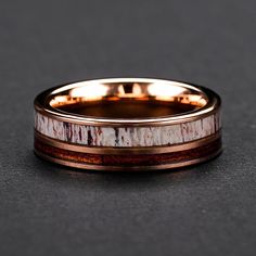 a close up of a wedding ring on a black surface with red and white stripes