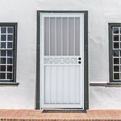 a white door with bars and windows on the side of a building