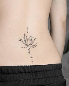 a woman's lower back tattoo with a flower on it