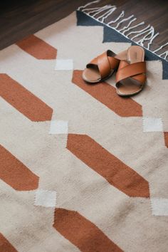 a pair of sandals sitting on top of a rug