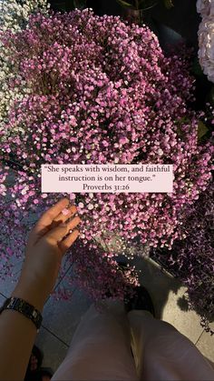 someone is holding up a pink flower with a quote on it that says she speaks with wishes, and beautiful instruction is on her tongue