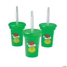 three plastic cups with straws in the shape of santa hats and grin face on them