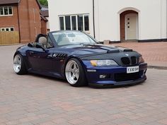 a blue convertible car parked in front of a house