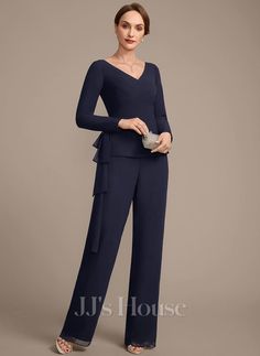 a woman in a blue jumpsuit and matching heels is posing for the camera with her hands on her hips