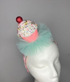 Sprinkles cupcake in pink glitter wrapper with cherry on top - blue/aqua  tulle - 1 inch wide white satin headband striped with pink ribbon  Lightweight and comfortable  One size fits most Whimsical Party Supplies For Birthday And Carnival, Fun Birthday Hair Accessories With Matching Headband, Fun Hair Accessories With Matching Headband For Birthday, Fun Pink Headband For Birthday, Cute Blue Party Hair Accessories, Whimsical Pink Headband For Party, Whimsical Pink Headband For Birthday, Pink Headband For Birthday, Fun Pink Hair Accessories For Birthday