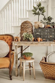 a table with some plants on top of it next to a chair and other items