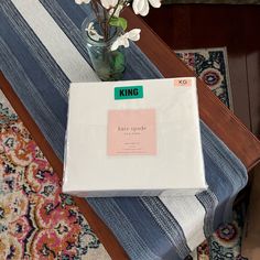 a box sitting on top of a table next to a vase with flowers in it