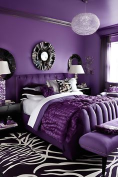 a bedroom decorated in purple and white with zebra print rugs on the floor, chandelier above bed