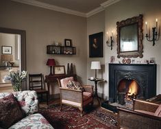 a living room filled with furniture and a fire place next to a wall mounted mirror