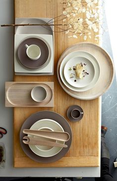 a wooden table topped with plates and bowls