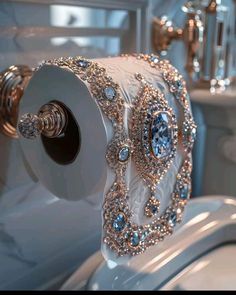 a fancy toilet paper holder with jewels on it