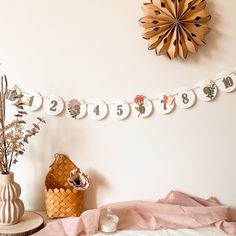 there is a clock on the wall next to a basket with flowers and other decorations