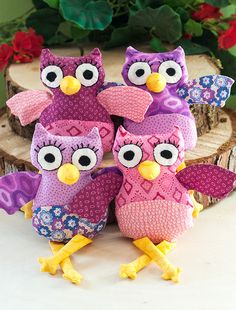 three purple and pink owls sitting next to each other