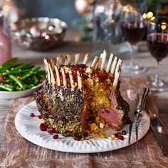 a large piece of meat is on a plate with forks and garnishes