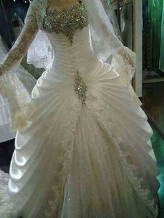 a white wedding dress with long sleeves on display