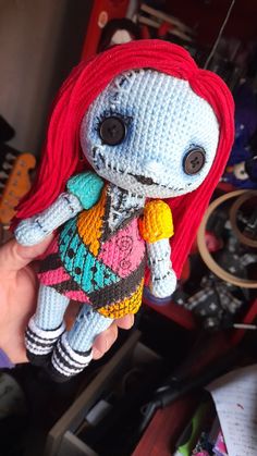 a crocheted doll with red hair is holding it's head in the air