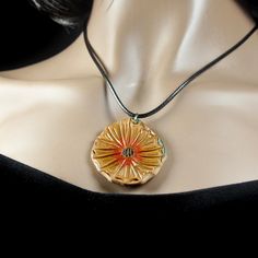 a woman wearing a necklace with an orange flower on it