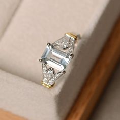 an engagement ring with two diamonds on it sitting in a white velvet cushioned box