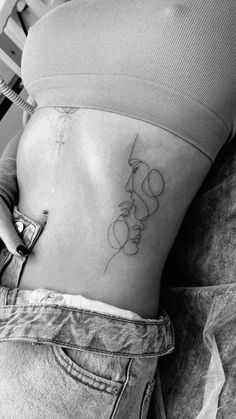 a woman's stomach with the word love tattooed on her lower side ribcage