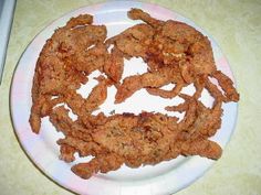 fried food on a white plate sitting on a table