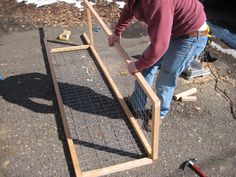 a man is working on something outside in the snow with wood and wire attached to it