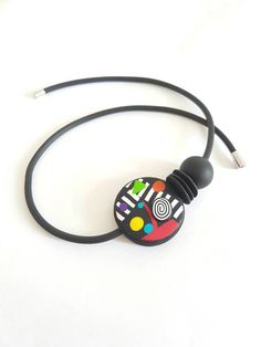 a black cord necklace with a colorful design on it