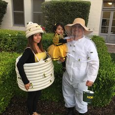 two women and a child dressed up in bee costumes, standing next to each other