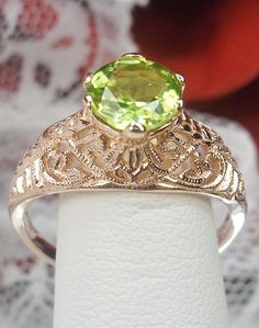 Natural Green Peridot Ring Corset Design#199 Custom Made This is a stunning Art Deco reproduction in sterling silver and rose gold plating filigree with a 1ct natural peridot. The peridot is 8mm in diameter. The inside of the band is marked 925 for sterling. Notice the beautiful craftsmanship of the rose gold filigree setting and band. This is a ornate and detailed ring. This is a lovely rendition of an antique filigree ring; and it is ready to wear. A gift ring box is included for safe keeping. Elegant Green Filigree Ring For Wedding, Antique May Birthstone Rings For Wedding, Elegant Filigree Ring For Wedding With May Birthstone, Antique May Birthstone Wedding Rings, Elegant Green Filigree Ring For Anniversary, Green Peridot Jewelry For Wedding, Green Filigree Ring With Intricate Design For Wedding, Green Oval Filigree Ring For Wedding, Wedding Ring With Hallmarked Peridot