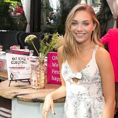 a woman standing in front of a counter with flowers