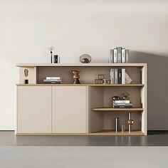 a shelf with books and other items on it in a room that is painted white