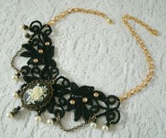 "This beautiful necklace has an antique gold filigree pendant with rose cameo setting, pearl beads, gold plated bead caps, seed beads, metal chain and black lace with rhinestone accents. It is 13\" long adjustable to 17\" long. Lobster clasp." Gothic Gold Pendant Necklace, Cameo Pendant For Jewelry Making, Victorian Pendant Necklace With Cabochon, Victorian Cabochon Pendant Necklace, Victorian Cabochon Necklace For Wedding, Adjustable Gold Cameo Jewelry, Ornate Necklace With Intricate Design For Vintage Events, Elegant Adjustable Bronze Necklace, Victorian Filigree Necklaces For Vintage Events