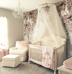 a baby's room with pink flowers on the wall and white crib in the corner