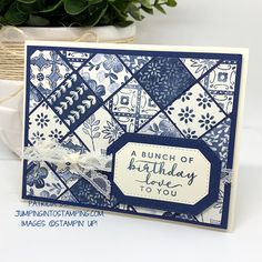 a blue and white birthday card on a table with a potted plant in the background