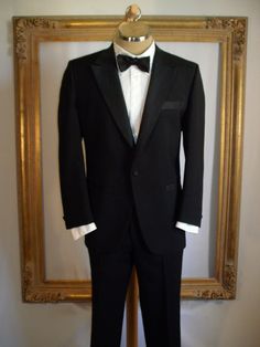 This is a super tuxedo with tone on tone design on the lapels. pockets, buttons, side stripe of trousers and on the attached cumberbund. Jacket is fully lined and trousers are partially lined. Maker: Lebaron California Clothes for Dorman Winthrop Fabric content: Not listed Care: Dry clean Condition: Great, overall, but there are two tiny moth bites (?) about 5 1/2 inches under the left pocket (laying flat).  Size: 44 Short (as labeled but please refer to measurements) Measurements: (Laying on a flat surface, double where necessary) Jacket: Shoulder to shoulder: 18 inches Underarm to underarm: 23 inches Waist: 23 inches Hips: 24 inches Sleeve length: 24 inches Length: 32 inches Trousers: Waist: 20 inches Inseam: 27 1/2 inches with a 2 1/2 inch hem Length: 38 1/4 inches Classic Black Tie Tuxedo With Lapel Collar, Classic Tuxedo With Lapel Collar For Black Tie, Classic Evening Single-breasted Suit, Classic Formal Tuxedo With Welt Pockets, Classic Wedding Tuxedo With Welt Pockets, Classic Single-breasted Tuxedo For Black Tie, Classic Black Double Breasted Suit For Evening, Classic Single-breasted Suits For Black Tie Events, Classic Single Breasted Tuxedo For Evening