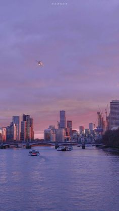 a city skyline with boats on the water and a plane flying in the sky above