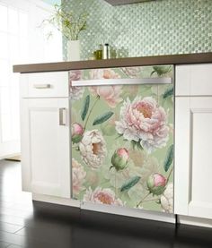 a kitchen with white cabinets and flowers on the backsplash, in front of a green tiled wall