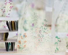 there is a vase with flowers on the window sill next to bookshelves