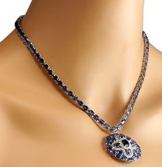 Stamped: 14K White Gold Total Necklace Weight: 29.0 Grams Necklace Length: 17 Inches Necklace Width: N/A Gemstone Weight: Total Natural Center Sapphire Weight is 1.25 Carat (Measures: 8.30x6.20 mm) Color: Blue Gemstone Weight: Total Natural Side Sapphire Weight is 54.45 Carat Color: Blue Diamond Weight: Total Natural Diamond Weight is 1.54 Carat Quantity: 54 Color: F-G, Clarity: VS2-SI1 Face Measures: 34.20x34.30 mm Sku: [702595W] 14k White Gold Diamond Necklace, White Gold Diamond Necklace, Gold Diamond Necklace, Natural Blue Sapphire, Blue Gemstones, Natural Sapphire, Blue Diamond, Necklace Length, White Gold Diamonds