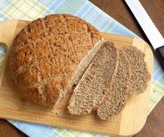 a loaf of bread sitting on top of a wooden cutting board next to a knife