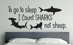 a bed with a wall sticker that says to go to sleep i count sharks not sheep