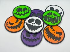 six halloween themed buttons on a white surface with black and orange faces in the center