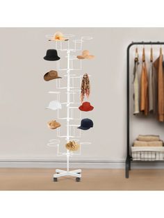 a hat rack with hats on it in front of a white wall and clothes racks