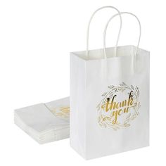 a white paper bag with gold foil lettering on it and thank you bags in front