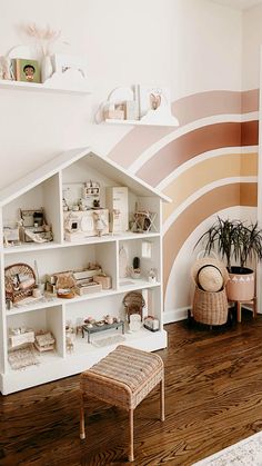 a doll house is on display in the corner of a room with wooden flooring