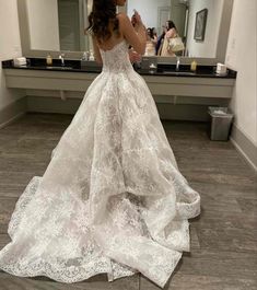 a woman is taking a selfie in front of a mirror wearing a wedding dress