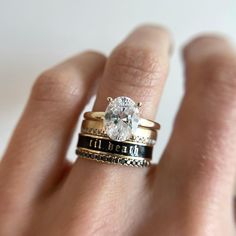 a close up of a person's hand holding a ring with a diamond on it