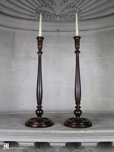 two candles sitting on top of a shelf